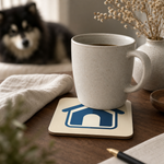 Dog House Icon Cork-Back Coaster for Finnish Lapphund Lovers Finnish Lapphund cork-back coaster in use on a table