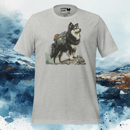 Light grey t-shirt featuring a Finnish Lapphund with a hiking pack standing confidently on rocks, perfect for outdoor-loving dog owners.