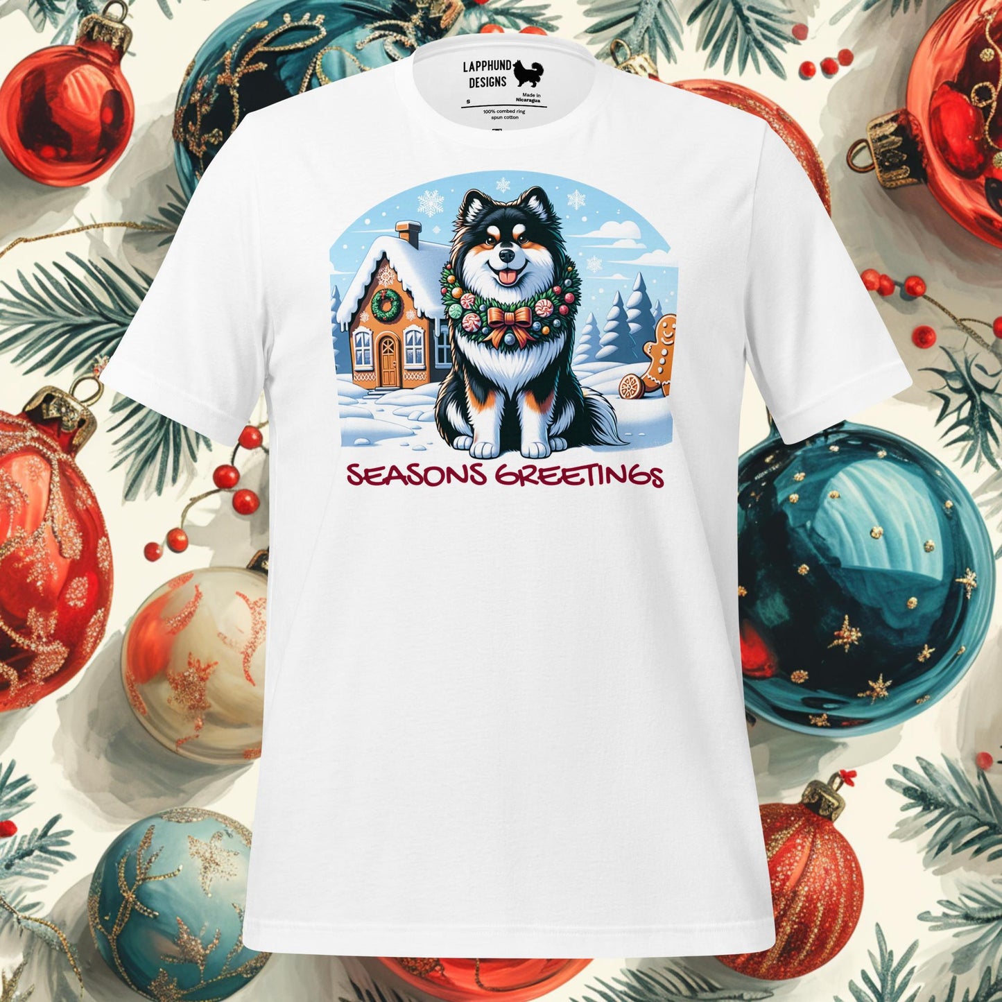 Season’s Greetings Finnish Lapphund Christmas t-shirt with a festive Lapphund, wreath, and gingerbread house in a snowy setting.