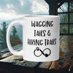 Finnish Lapphund Mug with "Wagging Tails & Hiking Trails" text and infinity paw print—ideal for dog lovers and hikers.  

