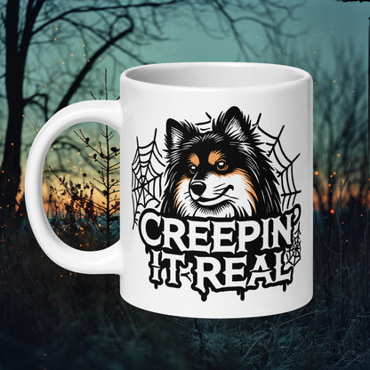 Mug featuring a Finnish Lapphund surrounded by spider webs with the text 'Creepin' It Real,' perfect for Halloween and dog lovers.