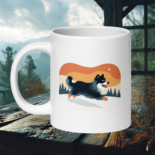 Ceramic mug featuring a playful Finnish Lapphund running through a snowy landscape with a retro sunset backdrop, perfect for nature and dog lovers.